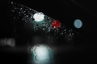 Close-up of wet glass against black background