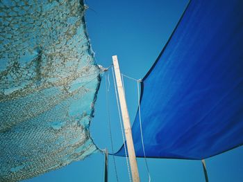 Low angle view of wind turbine against blue sky