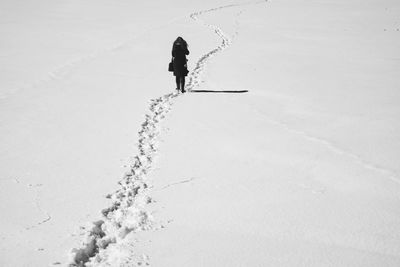 Man walking on snow covered sand