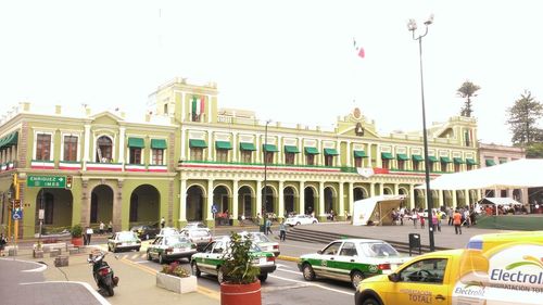 People in front of building against clear sky