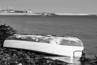 Boat moored on beach against sky