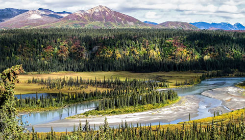 Scenic view of lake by mountain against sky