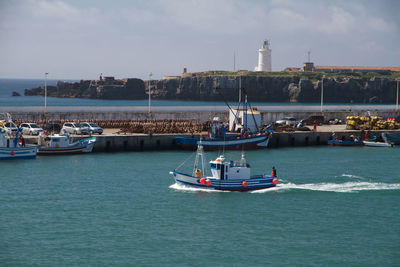 Boats sailing in sea against sky