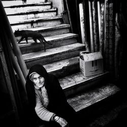 Portrait of woman sitting on staircase