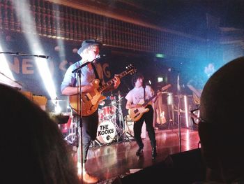 People playing guitar at music concert