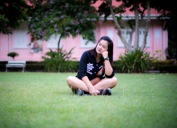 Full length of woman sitting on grass