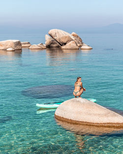 Woman on rock in lake tahoe
