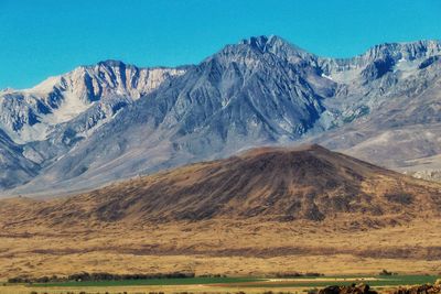 Scenic view of mountains against blue sky