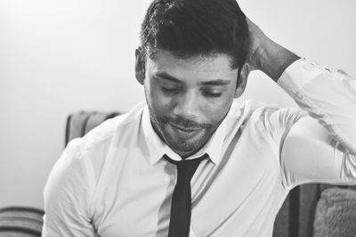 Man with hands behind head sitting at home