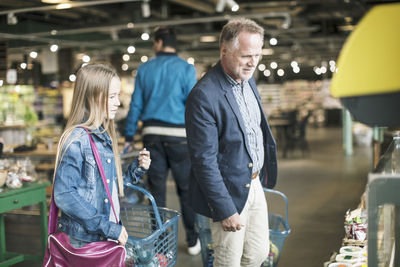 Father and daughter buying groceries at supermarket