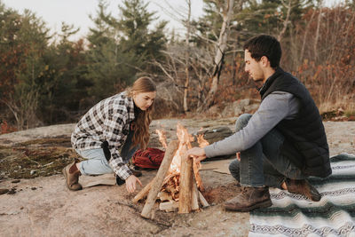Young couple sitting on wood in forest