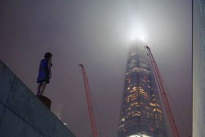 Low angle view of illuminated skyscraper against sky at night