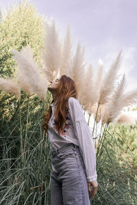 Woman standing on field against sky