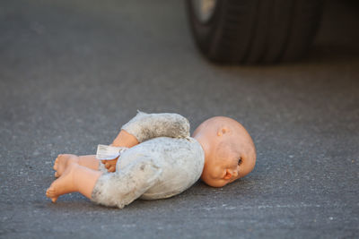 Close-up of abandoned doll on street