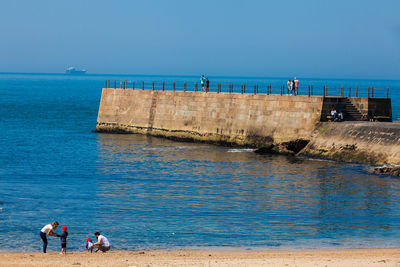 People on beach against sky