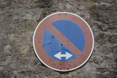 Close-up of road sign on stone wall