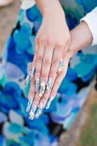 Midsection of woman with painted nail