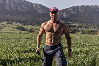Full length of shirtless man standing on field