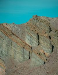 Low angle view of rock formation against clear blue sky