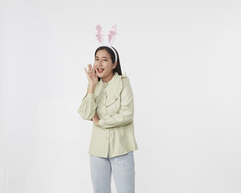 Portrait of a smiling young woman against white background