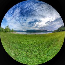 Scenic view of grassy field against cloudy sky