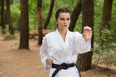 Portrait of young woman standing in forest