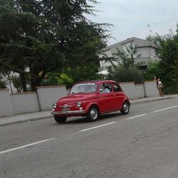 Side view of red car on road
