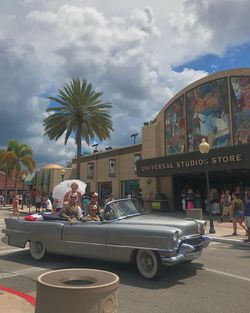 People on car against sky in city