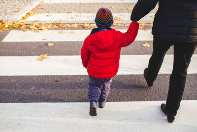 Rear view of woman and child crossing the street