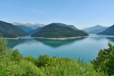 Scenic view of lake and mountains against sky