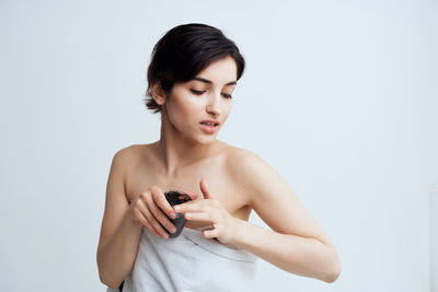 Young woman looking away against white background