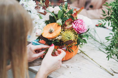 High angle view of woman holding flower on table