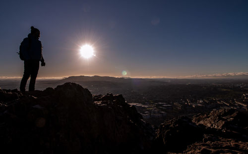 Silhouette woman standing against mountains during sunset