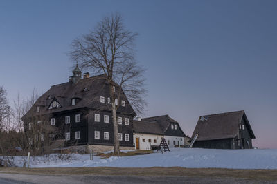 House on field against clear sky during winter