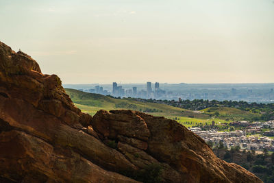 Rock formations in city against sky