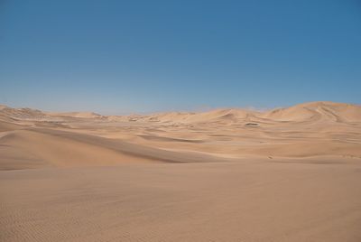 Scenic view of desert against clear blue sky