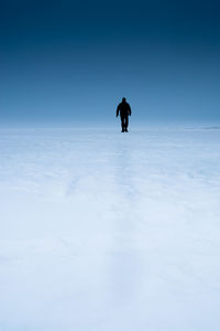 Silhouette man on snow against sky