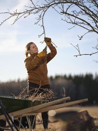 Woman cutting tree branches in spring