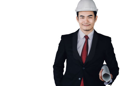 Portrait of young man standing against white background