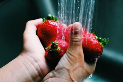 Close-up of hand holding strawberry