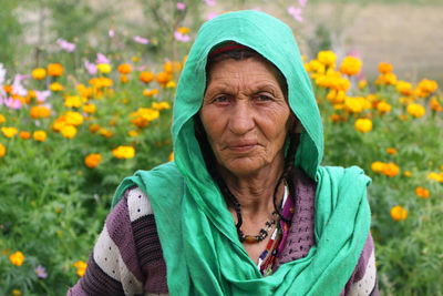 Portrait of senior woman by flowers