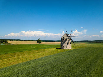 Traditional windmill on field against sky