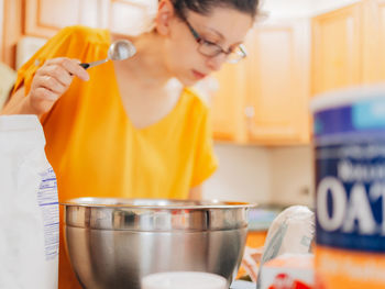 Young millennial mother at home in the kitchen preparing ingredients for apple crisp