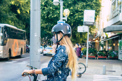 Woman with umbrella on street in city