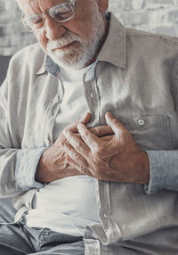 Portrait of senior man sitting on bed at home