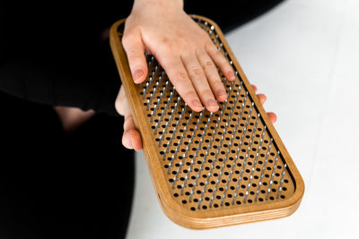 Person holding sadhu boards for nails standing practice, cropped picrure