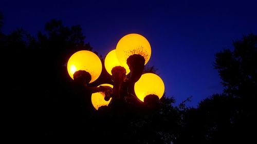 Low angle view of silhouette trees against clear sky at night