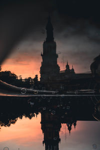 Reflection of building on lake during sunset