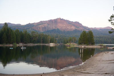 Scenic view of lake by mountain against clear sky