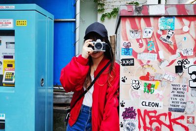 Full length of woman standing against graffiti